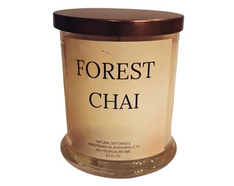 May include: A clear glass candle jar with a bronze lid. The label reads "FOREST CHAI". The candle is a natural soy candle, hand-poured in Jacksonville, FL, with a 60+ hour burn time and contains 12 fl oz.