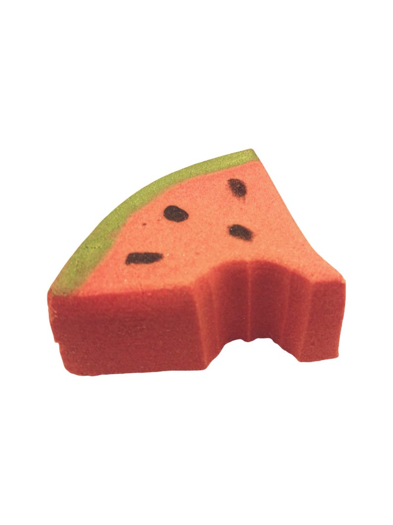May include: A watermelon-shaped sponge with a bite taken out. The sponge is red with black seed details and a green rind. The image is set against a white background.