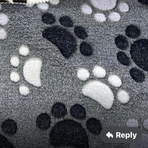 Pu&ograve; includere: Tessuto grigio con un motivo ripetitivo di impronte di zampe bianche e nere.