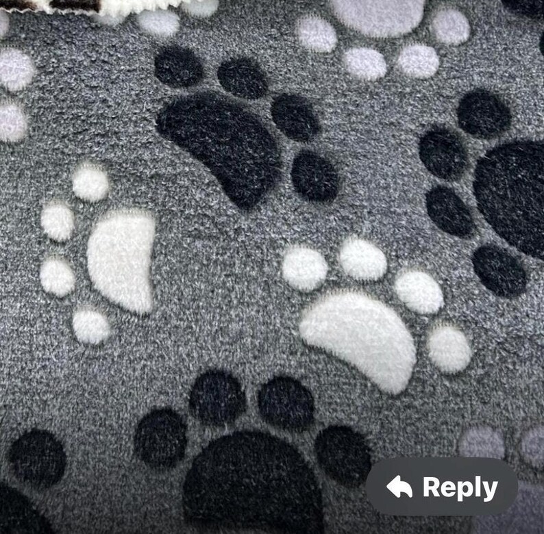 Pu&ograve; includere: Tessuto grigio con un motivo ripetitivo di impronte di zampe bianche e nere.