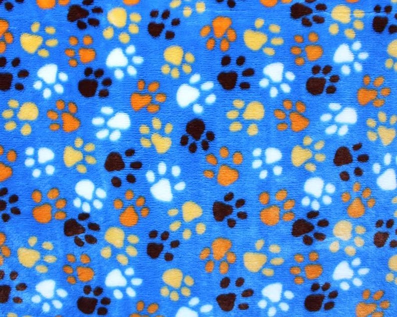 Pu&ograve; includere: Tessuto blu con un motivo ripetuto di impronte di zampe in vari colori, tra cui bianco, arancione e marrone.