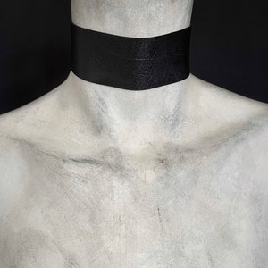 One and a half inch extra wide black vegan leather choker collar necklace. Piece closes in back with black metal nylon coated hook and is fully adjustable with a black metal nylon coated slider. Tags goth punk sexy dark fashion jewelry faux leather