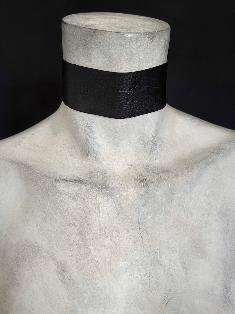 One and a half inch extra wide black vegan leather choker collar necklace. Piece closes in back with black metal nylon coated hook and is fully adjustable with a black metal nylon coated slider. Tags goth punk sexy dark fashion jewelry faux leather