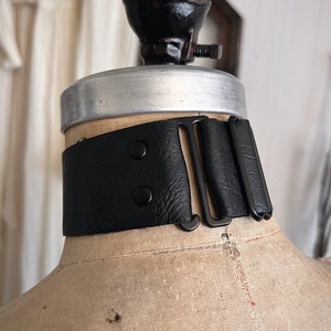 One and a half inch extra wide black vegan leather choker collar necklace. Piece closes in back with black metal nylon coated hook and is fully adjustable with a black metal nylon coated slider. Tags goth punk sexy dark fashion jewelry faux leather