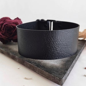 One and a half inch extra wide black vegan leather choker collar necklace. Piece closes in back with black metal nylon coated hook and is fully adjustable with a black metal nylon coated slider. Tags goth punk sexy dark fashion jewelry faux leather