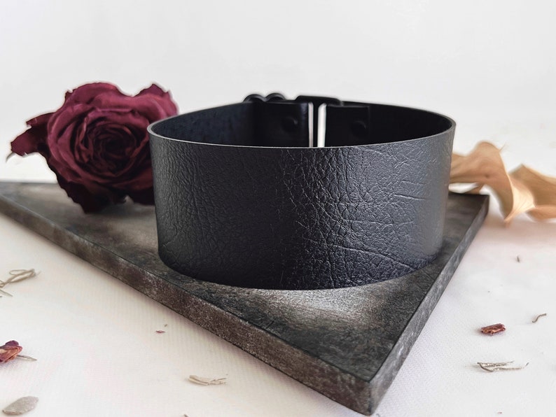 One and a half inch extra wide black vegan leather choker collar necklace. Piece closes in back with black metal nylon coated hook and is fully adjustable with a black metal nylon coated slider. Tags goth punk sexy dark fashion jewelry faux leather
