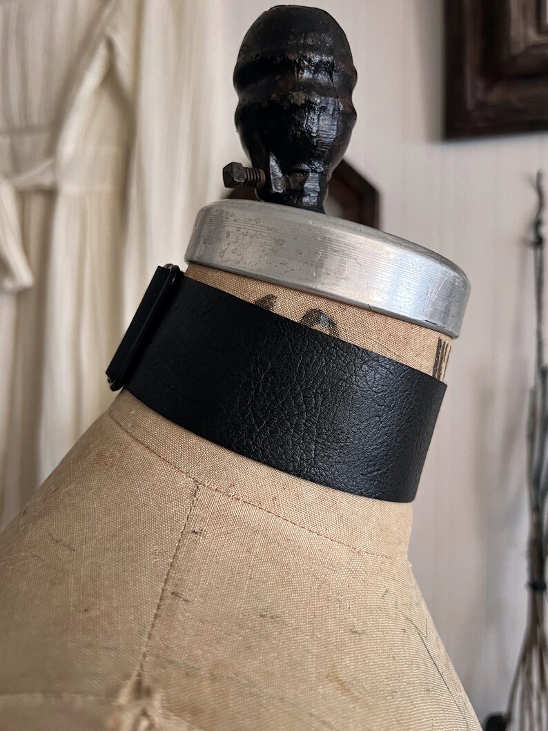 One and a half inch extra wide black vegan leather choker collar necklace. Piece closes in back with black metal nylon coated hook and is fully adjustable with a black metal nylon coated slider. Tags goth punk sexy dark fashion jewelry faux leather