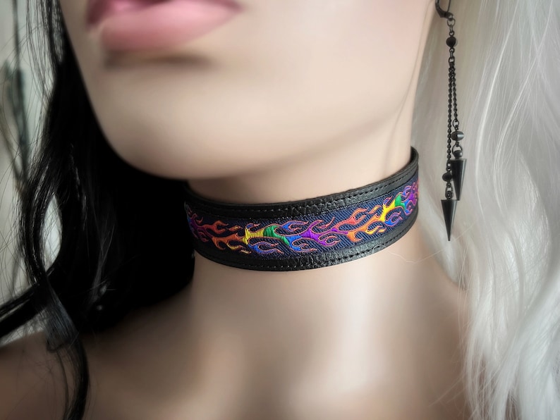 May include: A black leather choker with a rainbow flame design. The choker is adjustable and has a metal clasp.