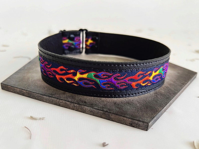 Rainbow flame print jacquard ribbon upper sewn onto a one inch wide black faux vegan leather choker collar base. Piece is adjustable and closes in back with a black metal hook. Tags lgbtq pride month queer gay goth flamer ribbon necklace punk rock