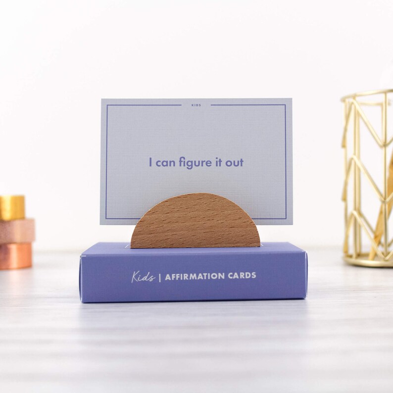 May include: A set of purple affirmation cards for kids with the text "Kids | Affirmation Cards" on the box. The top card reads "I can figure it out".