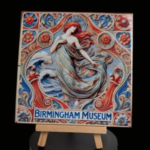 May include: A ceramic tile featuring a colourful image of a woman in a flowing blue dress standing in a wave. The tile has a decorative border with floral motifs and the text "BIRMINGHAM MUSEUM".