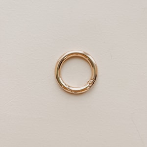 May include: A gold-toned metal key ring with a spring-loaded clasp.