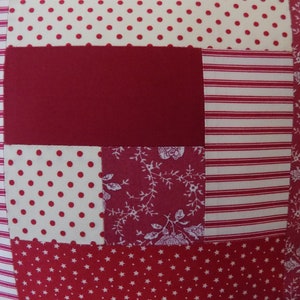 Puede incluir: Una tela de patchwork roja, blanca y rosa con una variedad de patrones, incluyendo lunares, rayas y dise&ntilde;os florales.