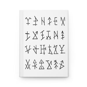 Może przedstawiać: Biały notatnik z czarnymi symbolami. Symbole są ułożone w rzędach i kolumnach na okładce. Notatnik ma czysty, minimalistyczny design, idealny do pisania lub szkicowania.