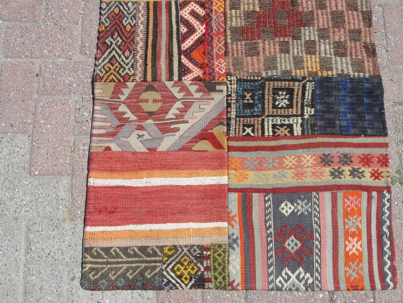 May include: A patchwork rug with a variety of colorful patterns and textures. The rug is made up of different pieces of fabric sewn together, creating a unique and interesting design.