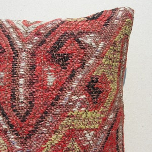 May include: A red, white, and yellow patterned throw pillow with a woven texture.