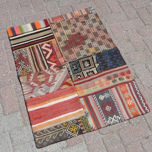 May include: A patchwork rug with a variety of colorful geometric patterns and designs. The rug is made of woven fabric and has a rustic, vintage look.
