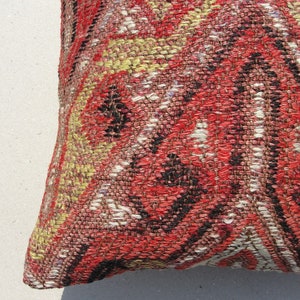 May include: A red, black, white, and yellow patterned throw pillow with a woven texture.