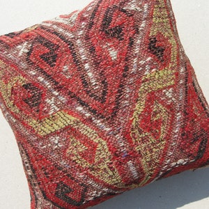 May include: A red, black, and yellow patterned throw pillow with a woven texture.