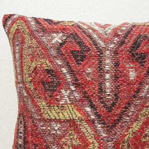 May include: A red, black, and white patterned throw pillow with a woven texture.