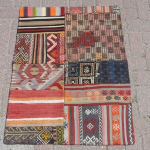 May include: A patchwork rug with a variety of colorful geometric patterns and designs. The rug is made of wool and has a rustic, vintage look.
