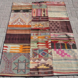 Könnte beinhalten: Ein rechteckiger Patchwork-Teppich mit verschiedenen geometrischen und abstrakten Mustern in Braun-, Orange-, Rot-, Grün- und Beigetönen. Der Teppich besteht aus verschiedenen zusammengenähten Stoffstücken.