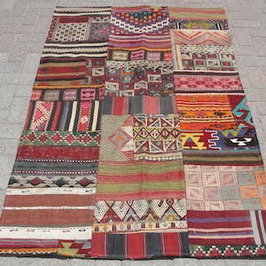 May include: A colorful patchwork rug made from different pieces of fabric. The rug is made up of various geometric patterns and colors, including red, blue, green, and yellow.