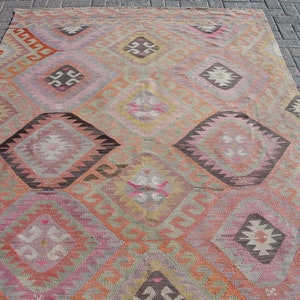 K&ouml;nnte beinhalten: Ein antiker t&uuml;rkischer Teppich mit einem geometrischen Muster in Rosa-, Orange-, Braun- und Beiget&ouml;nen. Der Teppich hat ein rautenf&ouml;rmiges Design mit komplizierten Details.