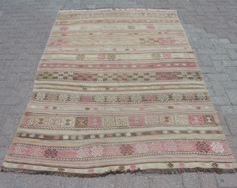 May include: A rectangular, beige rug with horizontal stripes in shades of pink and brown. The rug features geometric patterns and a fringed edge. This handmade rug is suitable for home decor.