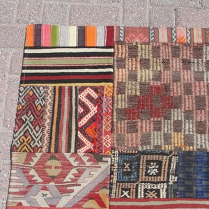 May include: A patchwork rug with a variety of colorful patterns and textures. The rug is made up of several different pieces of fabric, each with its own unique design. The rug is a beautiful example of traditional Turkish craftsmanship.