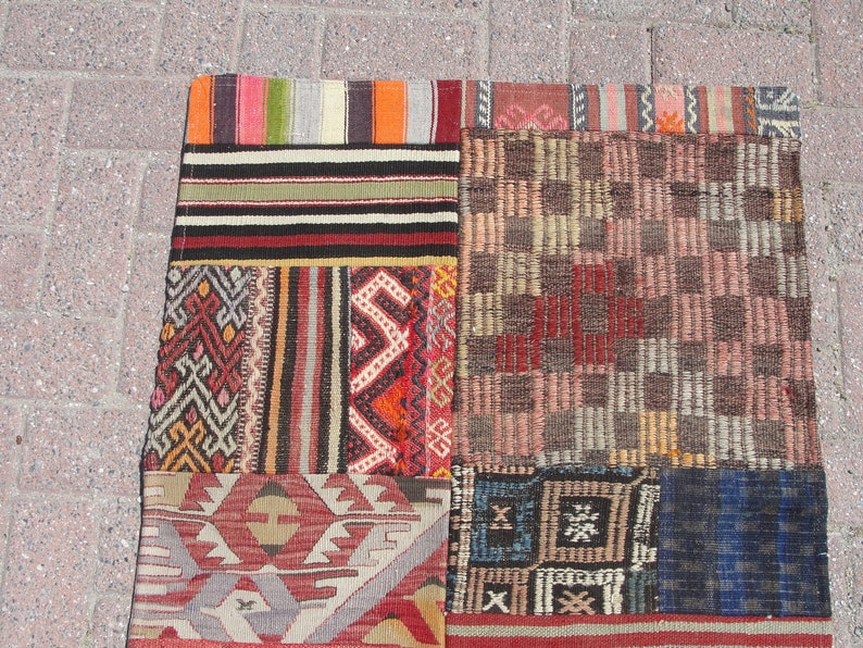 May include: A patchwork rug with a variety of colorful patterns and textures. The rug is made up of several different pieces of fabric, each with its own unique design. The rug is a beautiful example of traditional Turkish craftsmanship.