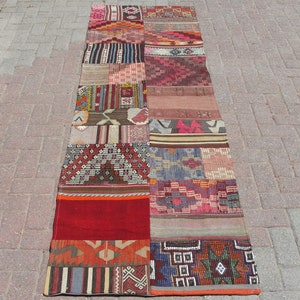 Puede incluir: Una alfombra larga y rectangular de patchwork con una variedad de patrones y diseños coloridos. La alfombra está hecha de diferentes piezas de tela cosidas juntas, creando un aspecto único y ecléctico. La alfombra es perfecta para agregar un toque de color y personalidad a cualquier habitación.