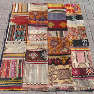 Puede incluir: Una alfombra de patchwork colorida con una variedad de patrones y diseños geométricos. La alfombra está hecha de diferentes telas y colores, incluyendo rojo, azul, verde, amarillo y marrón.