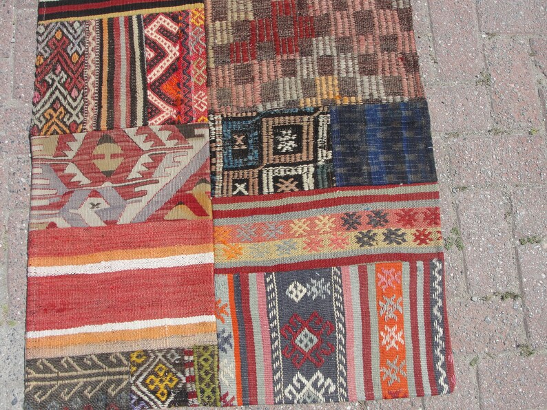May include: A patchwork rug with a variety of colorful geometric patterns and designs. The rug is made from different pieces of fabric sewn together.