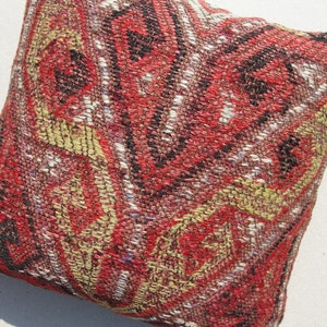 May include: A red, black, and gold patterned throw pillow with a woven texture. The pillow is made of a soft, comfortable fabric and is perfect for adding a touch of color and style to any room.