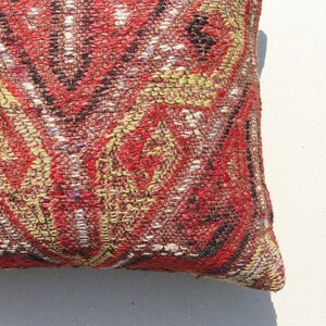 May include: A red, black, and gold patterned throw pillow with a woven texture.