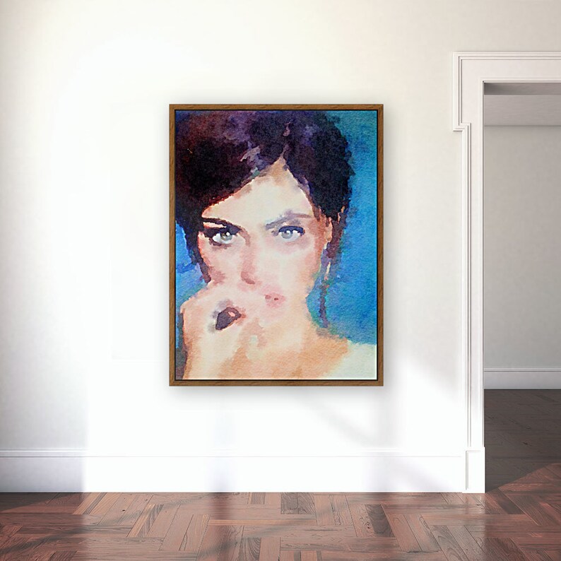 May include: A framed watercolour portrait of a woman with dark hair and striking blue eyes. The artwork features a blue background and a brown frame, creating a modern aesthetic. The woman is depicted with a thoughtful expression.