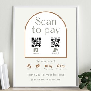 Könnte beinhalten: Ein weißes Schild mit einem braunen Bogen oben, auf dem "Scan to pay" steht. Es gibt zwei QR-Codes, einen für Venmo und einen für PayPal. Unter den QR-Codes steht "We also accept" und es werden Symbole für Bargeld, Karten, Apple Pay und Google Pay angezeigt. Das Schild sagt auch "thank you for your business" und "@YOURBUSINESSNAME".
