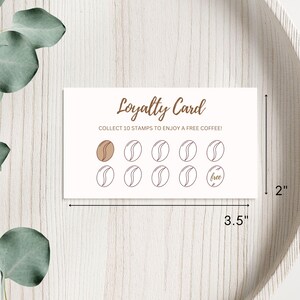 May include: A white loyalty card with brown text that reads "Loyalty Card" and "Collect 10 stamps to enjoy a free coffee!" The card has 10 circles, 9 of which are empty and 1 that says "free".
