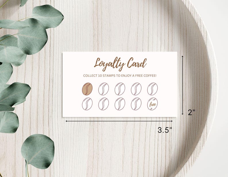 May include: A white loyalty card with brown text that reads "Loyalty Card" and "Collect 10 stamps to enjoy a free coffee!" The card has 10 circles, 9 of which are empty and 1 that says "free".