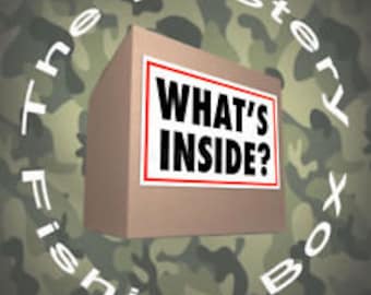 Puede incluir: Una caja de cartón marrón con las palabras "WHAT'S INSIDE?" impresas en una etiqueta blanca. La caja está rodeada de un patrón de camuflaje.