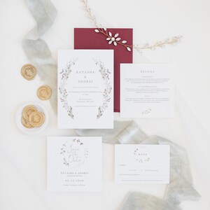 Winter wedding stationery suite with A6 invitation, square save the date, details card and A7 rsvp card with burgundy envelope and gold wax seals. Design features christmas foliage such as holly, mistletoe and spruce painted in watercolour.