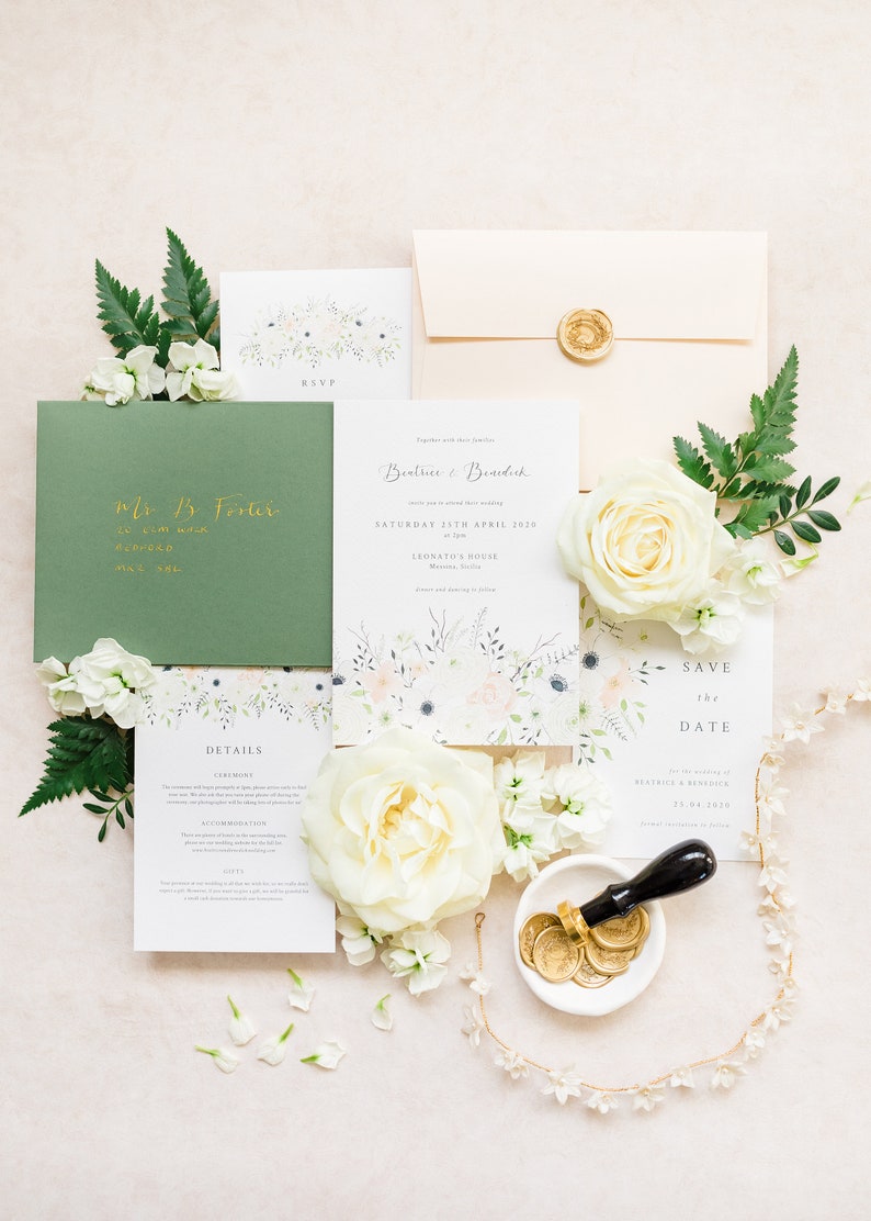 Wedding invitation suite flat lay with invitation, save the date, details and rsvp card with sage green and peach envelopes, gold calligraphy addressing and gold wax seal. The couples names are written in calligraphy. Printed on luxury white paper