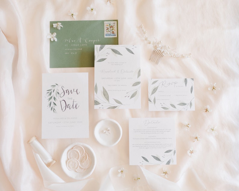 Wedding stationery suite with A6 invitation, save the date, square details card and A7 rsvp card. Sage green envelope with white calligraphy addressing and white wax seals.  Green watercolour foliage frames each design.