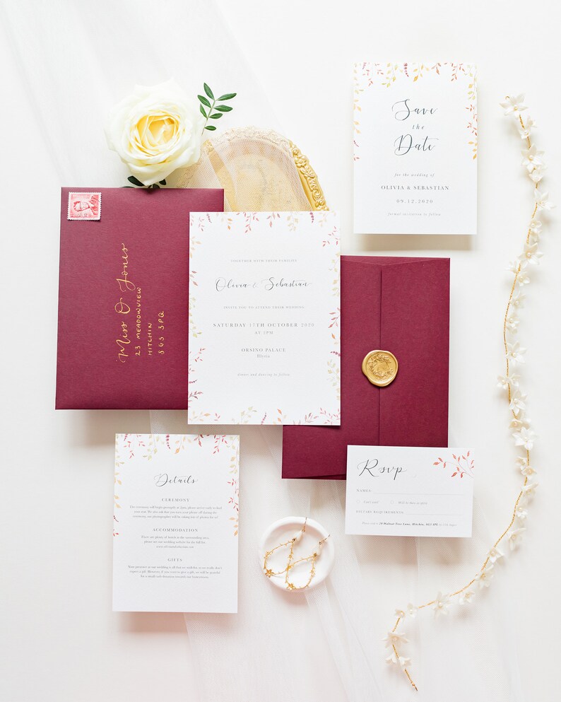 Full stationery suite for an autumn wedding. With invite, save the date, details and RSVP card. All designs feature watercolour autumn leaves in burgundy, burnt orange and gold. Designs are paired with burgundy envelopes with gold calligraphy