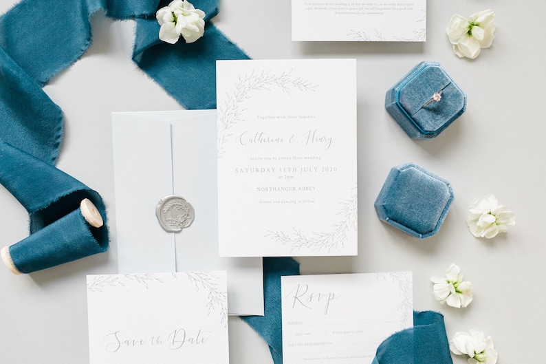 Wedding stationery suite with A6 invitation, save the date and A7 RSVP card with pale blue envelope and silver wax seal. Design features illustrated branches of delicate foliage and calligraphy names.