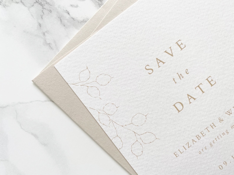 Close up of illustration detail on top corner of wedding save the date card with pale sand coloured envelope. Hand drawn honesty branches in delicate line drawing style with save the date in clean and modern serif font.