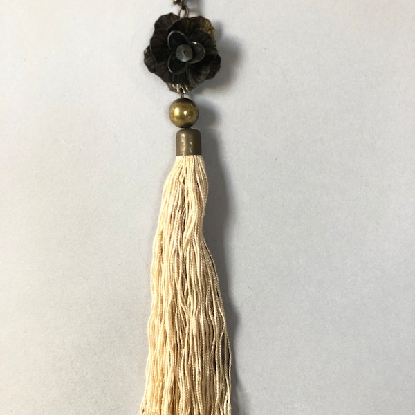 A bronze rose pendant with long cream silk  tassel. Quite Chinese in look.
