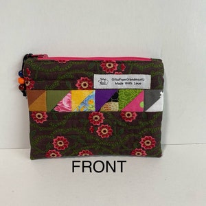 May include: A brown zippered pouch with a floral pattern and a patchwork design. The pouch has a pink zipper and a label that reads "GiftsFromGrandmaAU Made With Love".