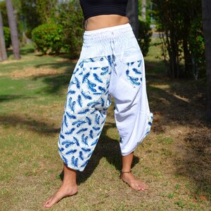 Op de afbeelding: Witte broek met een blauwe verenprint. De broek heeft een wijde pijp en een trekkoord in de taille.